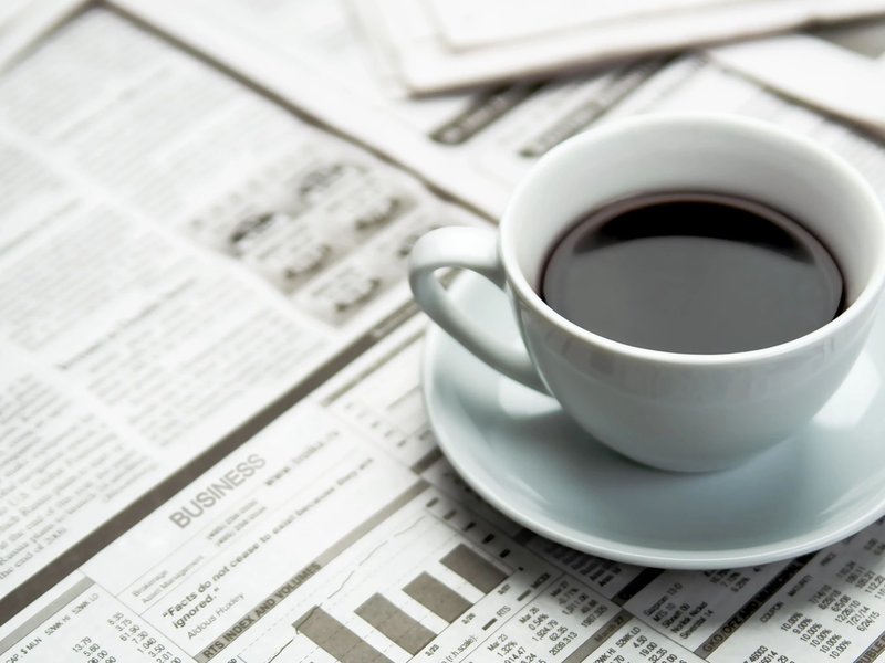 A cup of coffee on the newspaper from ICD Flooring in Hermitage